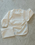 Micasso & Co Bavette à manches longues 6-24 mois avec pochette intégrée qui attrape la nourriture 6-24 mois Alimentation Micasso & Co Blanc